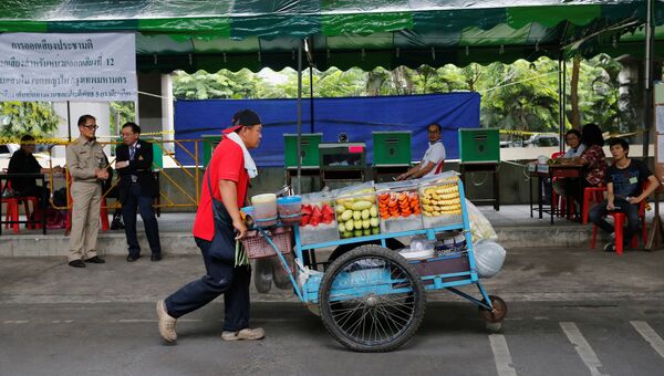 Продавец фруктов у избирательного участка в Бангкоке во время проведения референдума по конституции Таиланда. 7 августа 2016