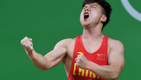 Спортсмен из Китая во время соревнований по тяжелой атлетике на летних Олимпийских играх в Рио-де-Жанейро