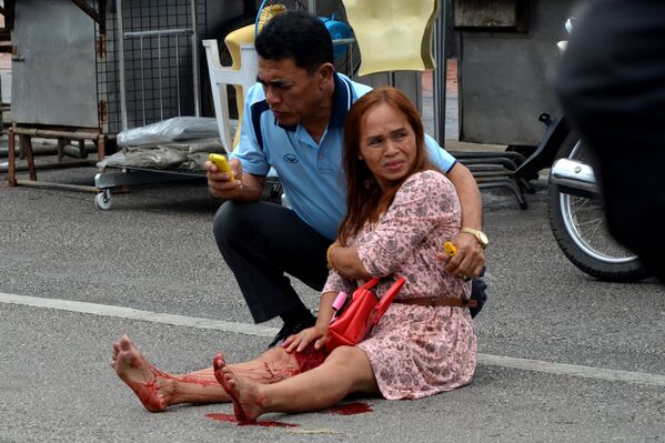 Полицейский с пострадавшей на месте взрыва в Таиланде