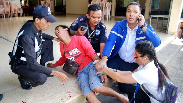 Полицейские с пострадавшим на месте взрыва в Таиланде. 12 августа 2016