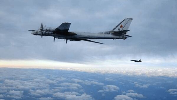 Палубный истребитель F/A-18 Хорнет сопровождает российский стратегический бомбардировщик Ту-95 после облета последним авианосца Нимиц