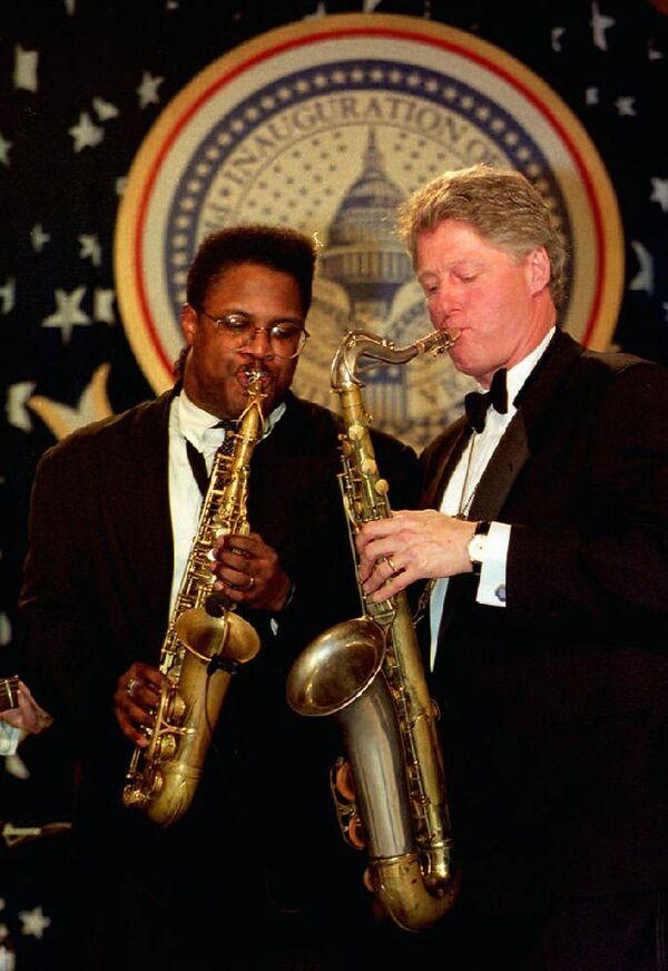 Президент США Билл Клинтон играет на саксофоне вместе с музыкантом Джо Хендерсон в Арканзасе во время бала состоявшегося после его инаугурации