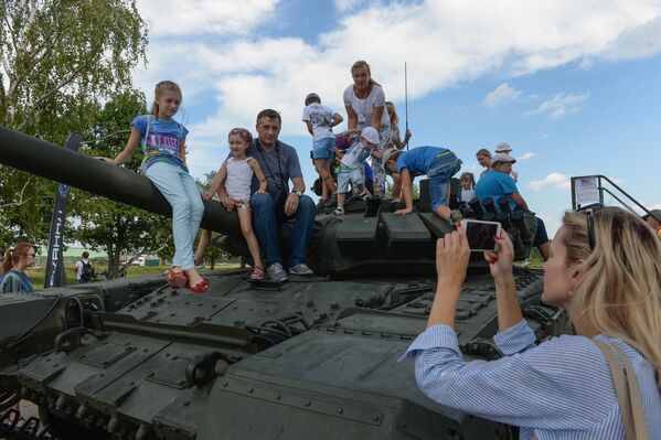 Посетители выставки фотографируются на танке Т-90 во время соревнований по танковому биатлону на полигоне Алабино