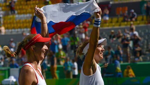 Екатерина Макарова и Елена Веснина (Россия) радуются победе в финальном матче против Тимеи Бачински и Мартины Хингис (Швейцария) в парном разряде женского турнира по теннису на Олимпийских играх
