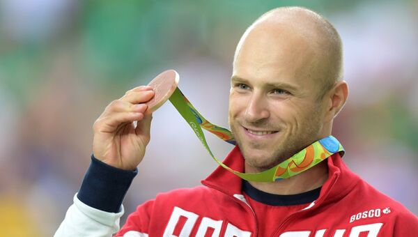 Денис Дмитриев (Россия), завоевавший бронзовую медаль в индивидуальном спринте на соревнованиях по трековым гонкам среди мужчин на XXXI летних Олимпийских играх, на церемонии награждения