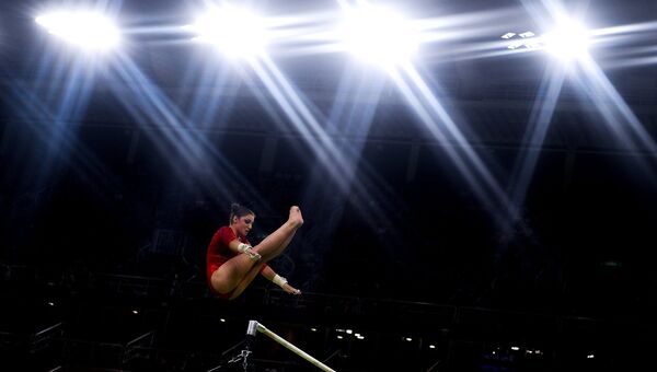 Алия Мустафина выполняет упражнения на разновысоких брусьях на XXXI летних Олимпийских играх