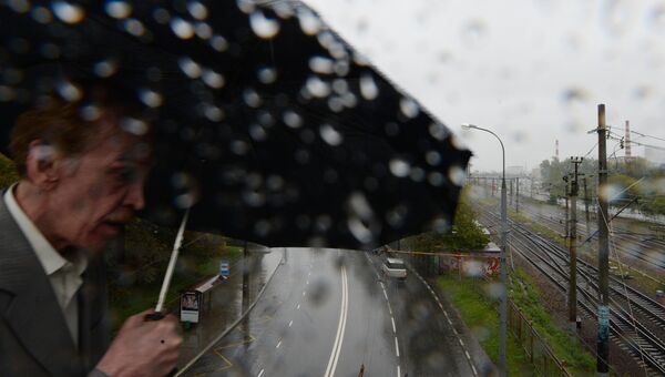 Мужчина во время дождя в Москве. Архивное фото