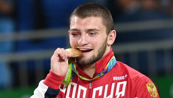 Давит Чакветадзе (Россия), завоевавший золотую медаль в соревнованиях по греко-римской борьбе в весовой категории до 85 кг на XXXI летних Олимпийских играх, на церемонии награждения