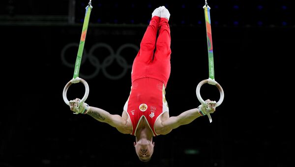 Российский гимнаст Денис Аблязин выполняет упражнения на кольцах на XXXI летних Олимпийских играх
