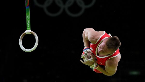 Российский гимнаст Денис Аблязин выполняет упражнения на кольцах на XXXI летних Олимпийских играх