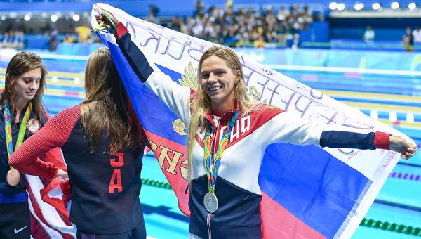 Призеры соревнований по плаванию на дистанции 100 м брассом среди женщин на XXXI летних Олимпийских играх во время церемонии награждения (справа налево): Юлия Ефимова (Россия) - серебряная медаль, Лилли Кинг (США) - золотая медаль, Кэти Мейли (США) - бронзовая медаль