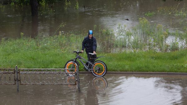 Велосипедист на затопленной улице. Архивное фото