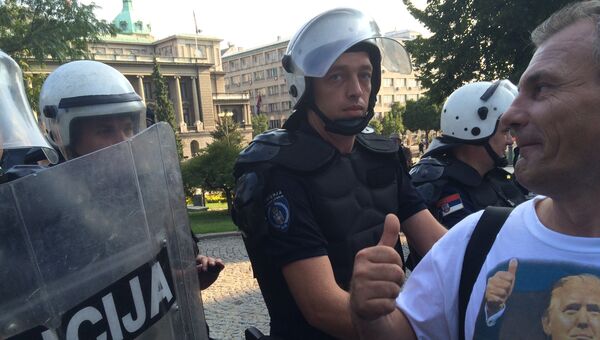 Участник акции протеста возле полицейского кордона в Сербии. Архивное фото