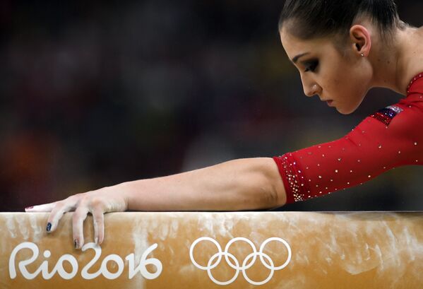 Алия Мустафина (Россия) выполняет упражнения на бревне в командном многоборье среди женщин на соревнованиях по спортивной гимнастике на XXXI летних Олимпийских играх