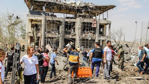 Сотрудники полиции и спасатели на месте взрыва у отделения полиции на востоке Турции