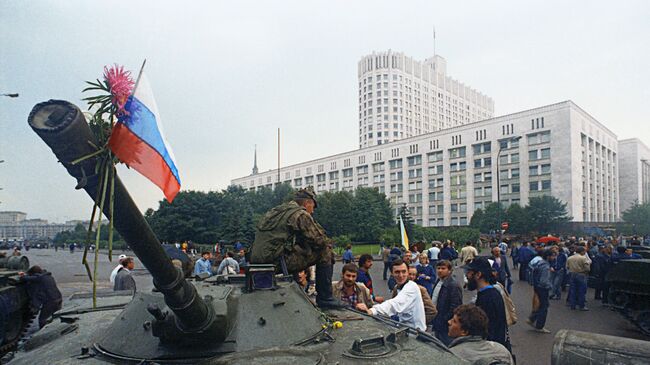 Защитники Белого дома прикрепили цветы к орудийному стволу одного из танков, введеных в Москву 19 августа 1991 года в связи с объявлением членами ГКЧП чрезвычайного положения в столице