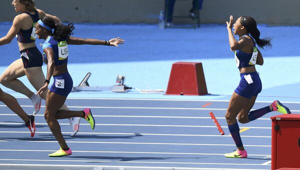 Американские бегуньи во время передачи эстафетной палочки на Олимпийских играх в Рио-де-Жанейро
