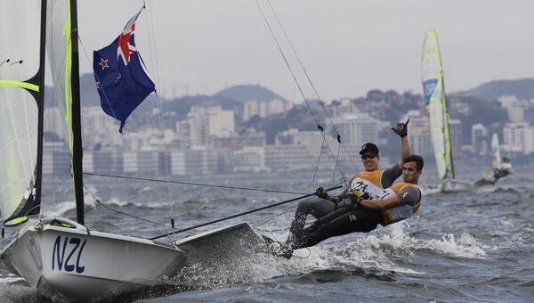 Новозеландские яхтсмены Питер Берлинг и Блэр Тьюк празднуют победу в соревнованиях по парусному спорту в классе 49er на Олимпиаде-2016 в Рио-де-Жанейро