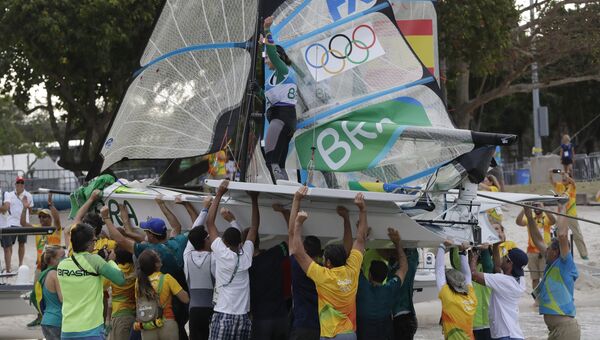 Члены бразильской парусной команды в классе 49er празднуют победу на летних Олимпийских играх в Рио-де-Жанейро