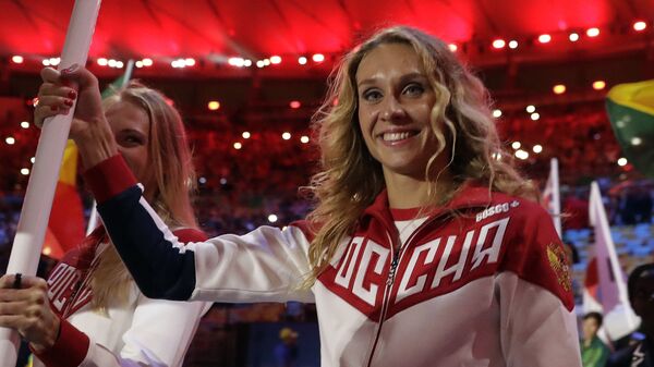 Наталья Ищенко (справа) и Светлана Ромашина несут флаг России на церемонии закрытия Олимпийских игр на стадионе Маракана в Рио-де-Жанейро