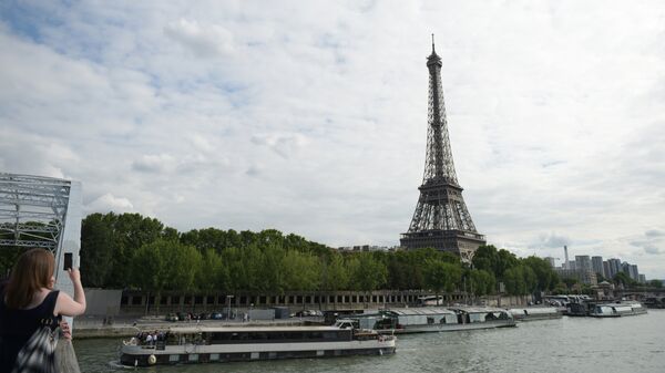 Девушка фотографирует с моста Эйфелеву башню в Париже. Архивное фото