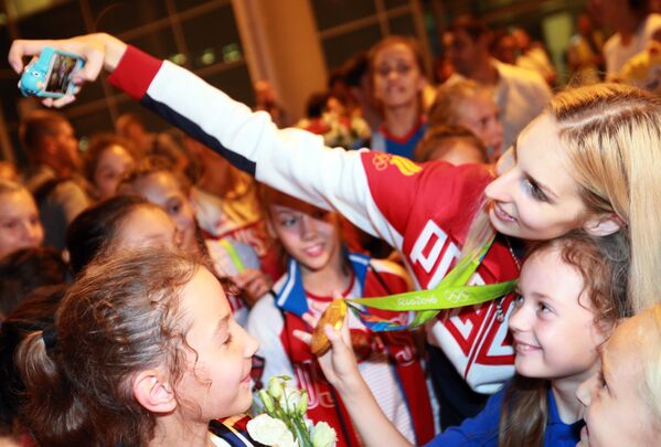 Спортсменка сборной России Анастасия Близнюк фотографируется с поклонницами во время церемонии встречи в аэропорту Шереметьево