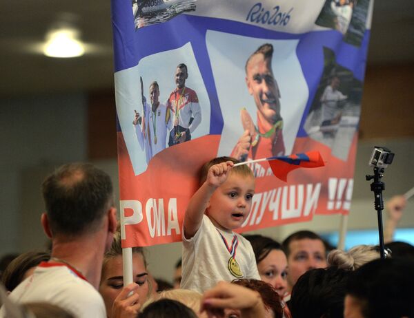Юный участник церемонии встречи золотого рейса с чемпионами и призерами XXXI Олимпийских игр в аэропорту Шереметьево