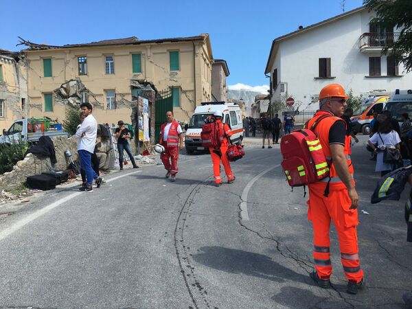 Сотрудники Скорой помощи и спасатели на одной из улиц города Аматриче после землетрясения