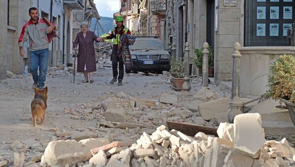 Люди на одной из улиц города Аматриче, пострадавшего в результате землетрясения. Архивное фото