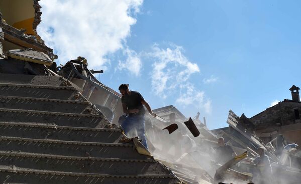 Люди разбирают завалы в городе Аматриче, пострадавшем в результате землетрясения