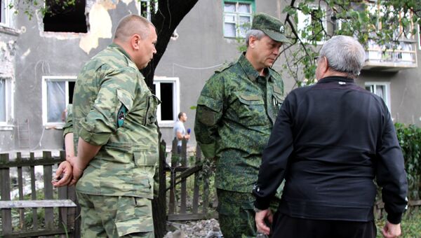 Заместитель командующего оперативным командованием ДНР Эдуард Басурин беседует с жителем Горловки, пострадавшей в результате обстрела