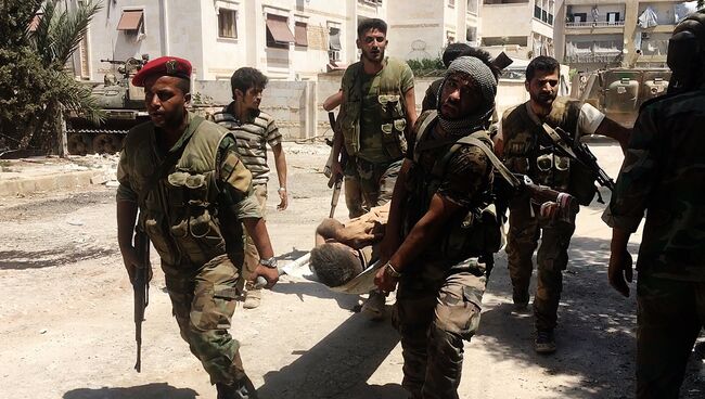 Бойцы сирийской армии выносят раненого