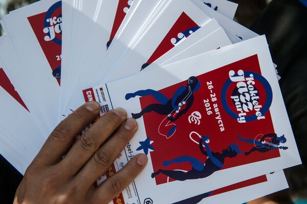 Волонтер раздает информационные брошюры накануне начала Международного джазового фестиваля Koktebel Jazz Party