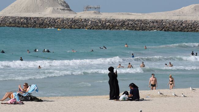 Отдыхающие на пляже в Дубае, ОАЭ. Архивное фото