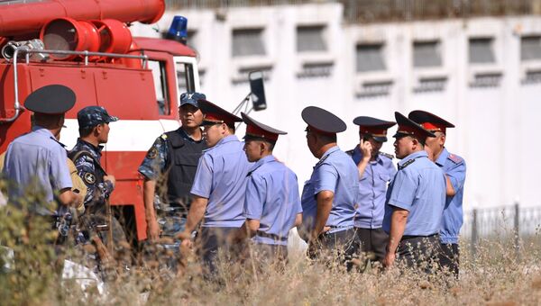 Сотрудники правоохранительных органов на месте взрыва автомашины марки Mitsubishi Delica, протаранившей ворота дипломатического представительства Китая в Бишкеке