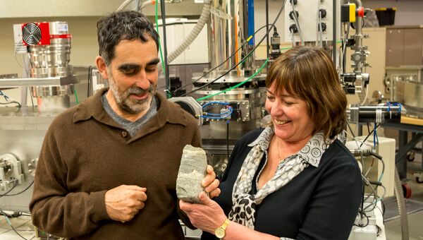 Ученые держат в руках строматолит, чей возраст превышает 3,7 миллиарда лет