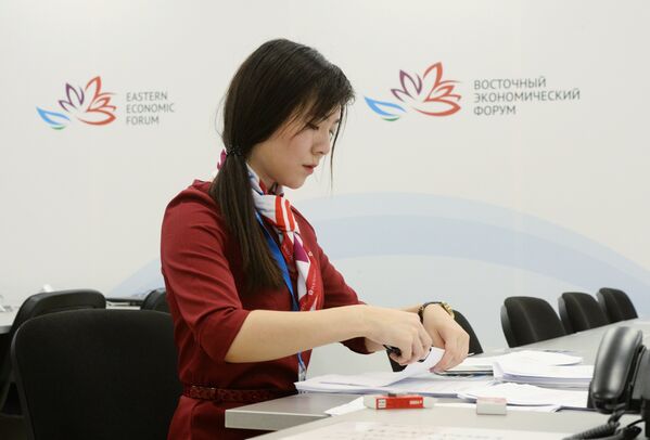 Волонтер готовит информационные материалы в пресс-центре Восточного экономического форума