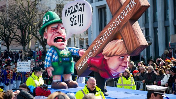 Карнавальная кукла, изображающая канцлера Ангелу Меркель, несущую крест с надписью: Гуманная миграционная политика, во время шествия в Дюссельдорфе, Германия