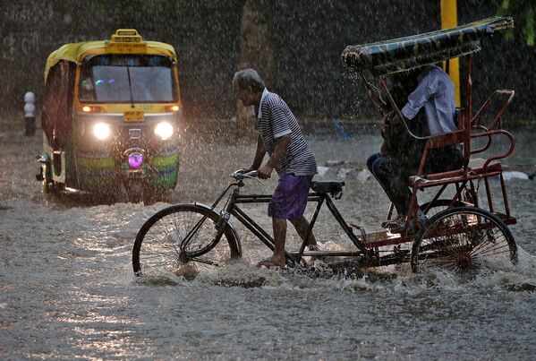 Водитель рикши во время дождя в Нью-Дели. Август 2016