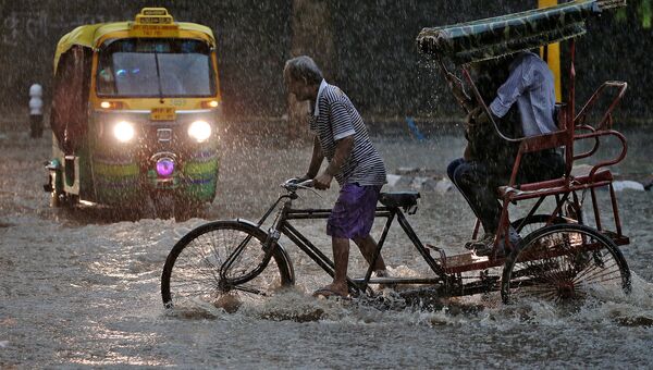 Водитель рикши во время дождя в Нью-Дели. Архивное фото
