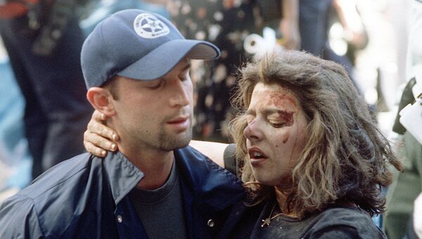 Доминик Гуаданоли помогает раненой женщине во время террористической атаки в Нью-Йорке. 11 сентября 2001 года