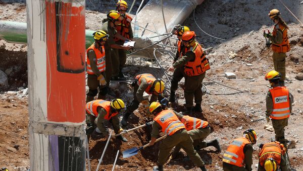 Израильские военные помогают искать людей под обломками рухнувшей парковки