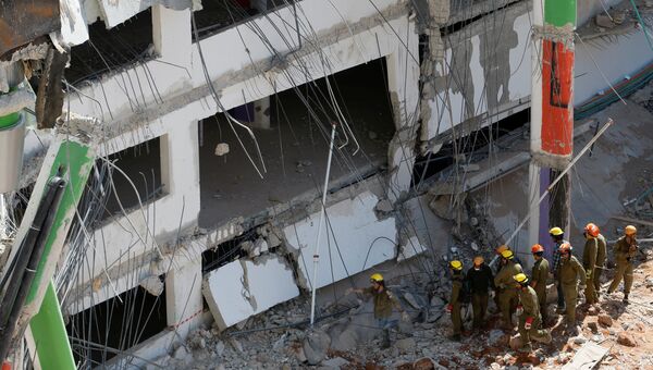 Спасатели во время поиска людей под обломками рухнувшей парковки в Тель-Авиве