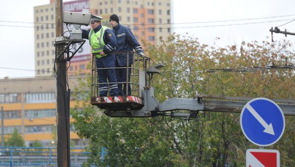 Сотрудник ДПС настраивает камеру автоматической фиксации нарушения правил дорожного движения в Москве. Архивное фото