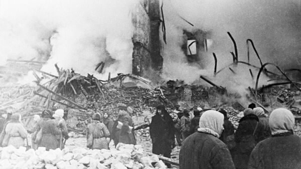 Жители Ленинграда стоят у разрушенного артобстрелом жилого дома в дни блокады