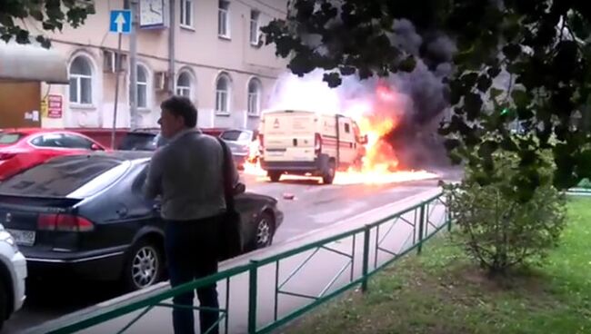 Горящая инкассаторская машина после налета в Москве. Кадр из видео