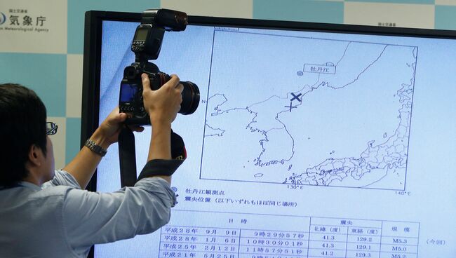 Журналист фотографирует карту Корейского полуострова с отмеченным местом сейсмособытия в КНДР. 9 сентября 2016