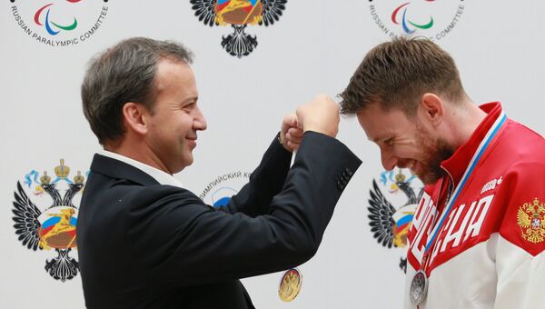 Аркадий Дворкович награждает Сергея Малышева - победителя соревнований в стрельбе из малокалиберного произвольного пистолета на Всероссийских паралимпийских соревнованиях