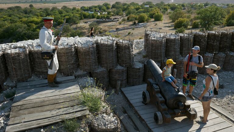 Участник реконструкции Крымская война и посетители на Крымском военно-историческом фестивале в поселке Первомайка Балаклавского района