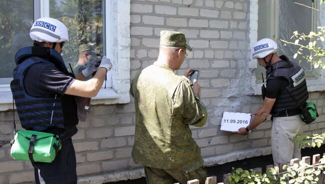 Представители ОБСЕ осматривают повреждения, нанесенные жилому дому в результате обстрела поселка Крутая балка. Архивное фото